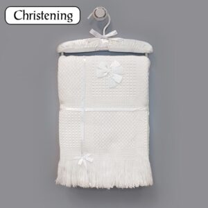 Personalised white baby christening shawl with satin bows and blue embroidery on a satin hanger.